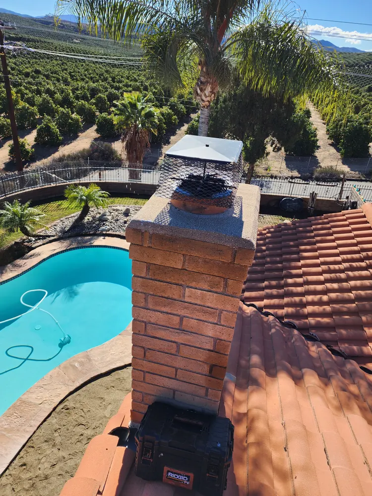 Brick chimney protected by a newly installed metal cap
